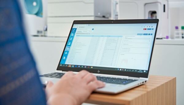 Assistante médicale qui utilise un ordinateur portable avec le logiciel Axenita dans un laboratoire de cabinet médical.